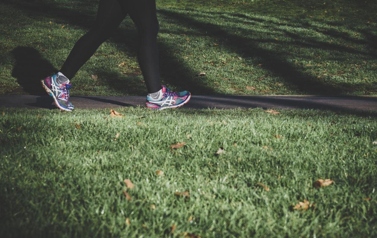 Image of someone's feet and legs on a grass path